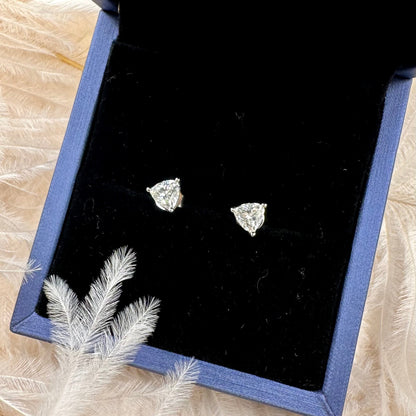 Diamond stud earrings in a jewelry box on a textured surface